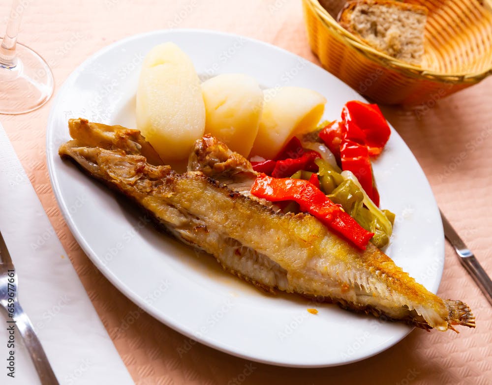 Dish of spanish cuisine - roasted maragota fish (ballan wrasse) with vegetables