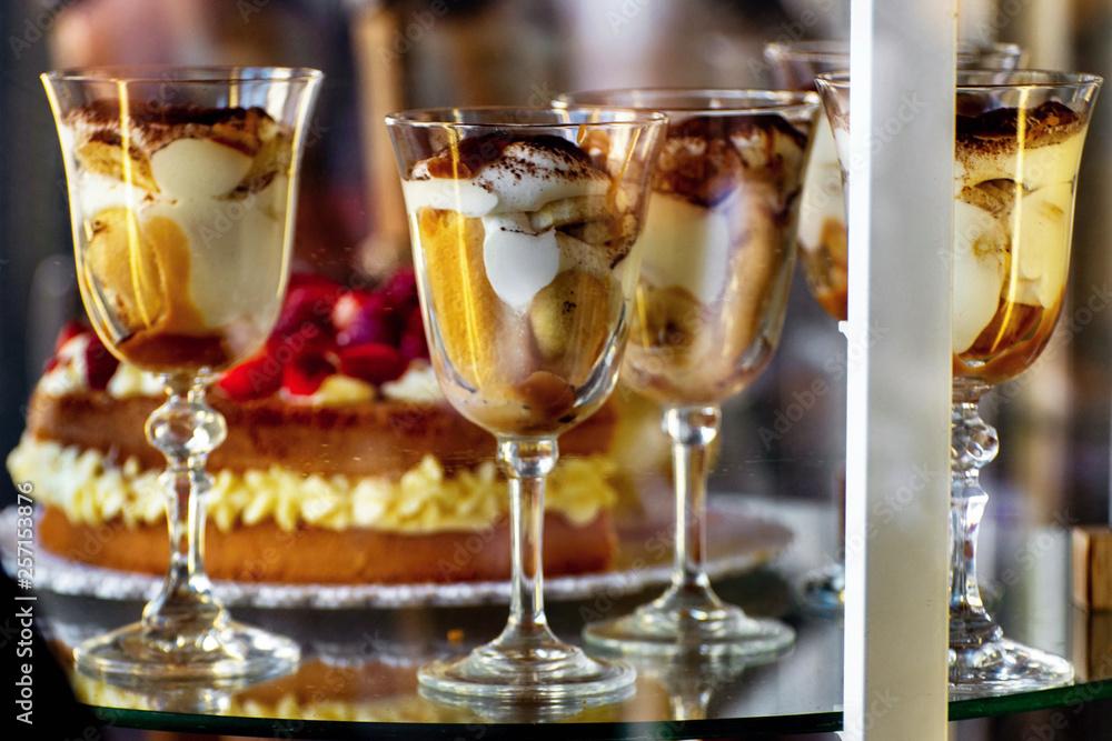 Sweet creams in goblets in glass show-case.