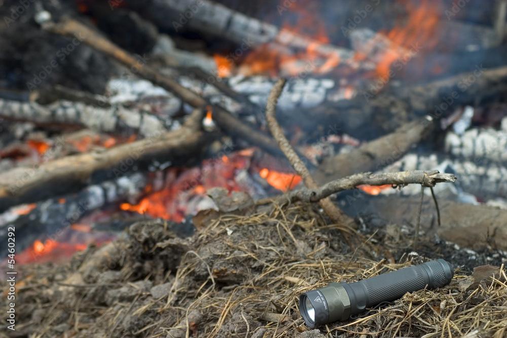 flashlight by a campfire