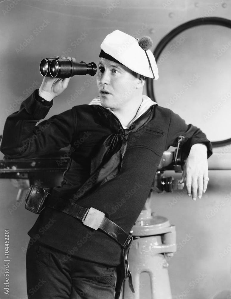 Portrait of sailor looking through binoculars 