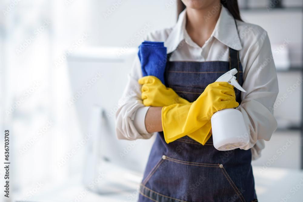 Asian housewife cleaning house and standing with arms crossed looking at camera