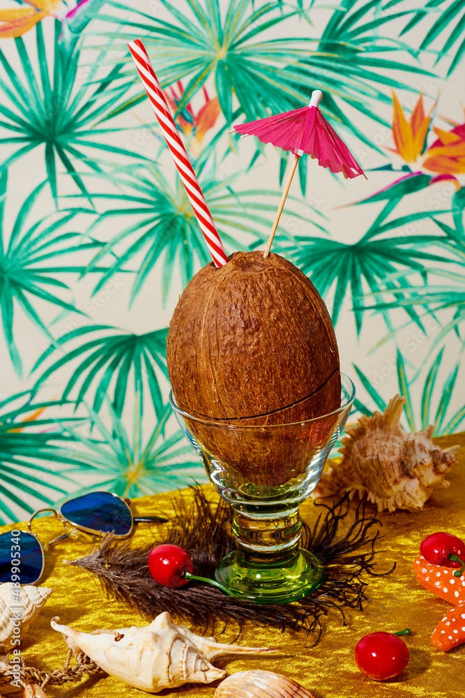 coconut in a glass with a drinking straw and a paper umbrella