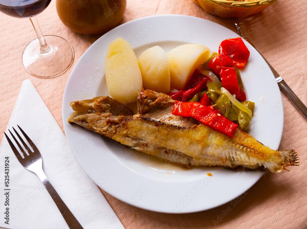 Dish of spanish cuisine - roasted maragota fish (ballan wrasse) with vegetables