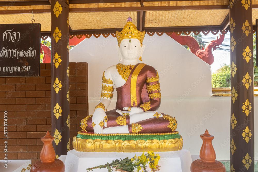 Phayao, Thailand - Dec 31, 2019: White God Statue Wear Gold Crown Sitting On Stone Base with Natural light in Wat San Mueng Ma or San Mueng Ma Temple Chiang Kham District at Phayao Thailand