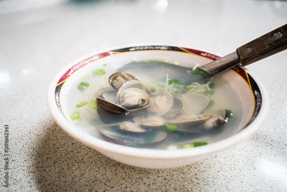 A bowl of Taiwanese clam soup in a night market restaurant.