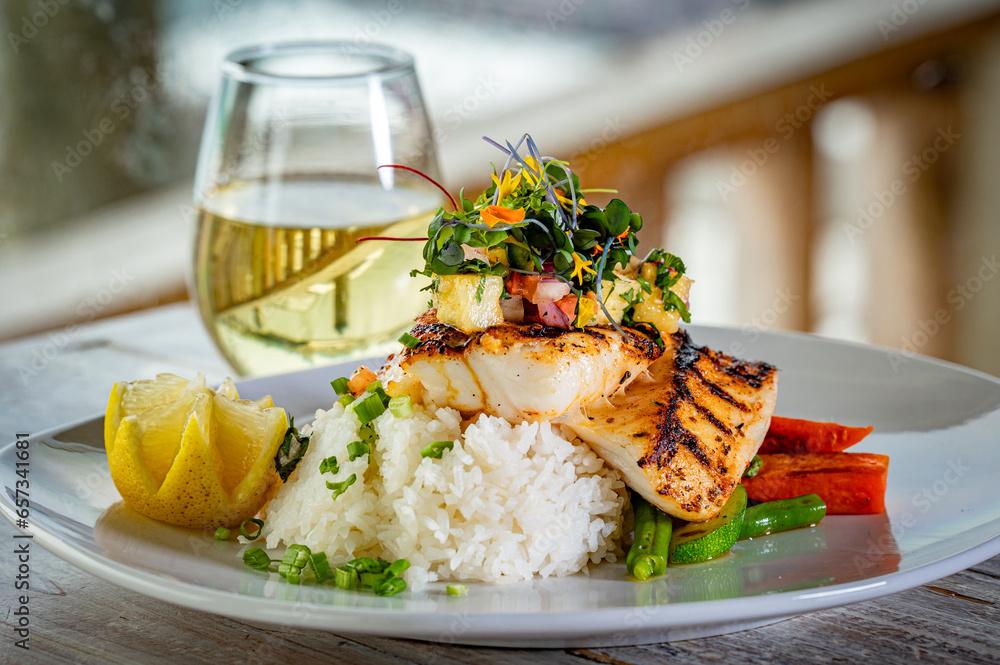 Blackened Black Grouper on a bed of rice and vegetables and topped with mango salsa and micro greens.