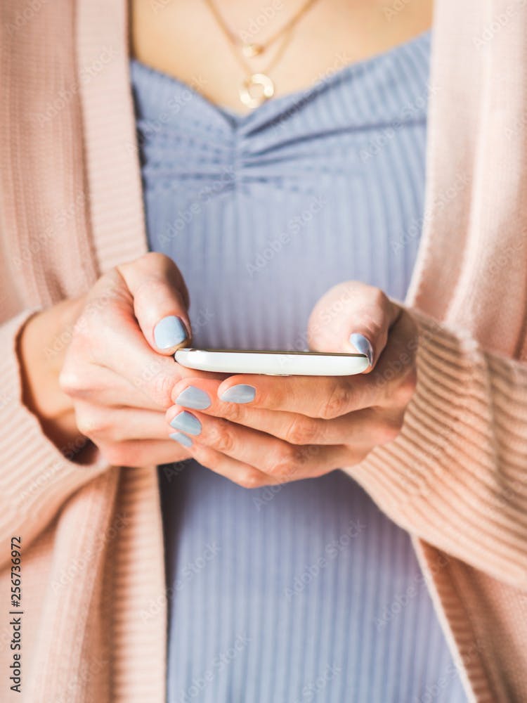 Woman using white smartphone. Pastel colors