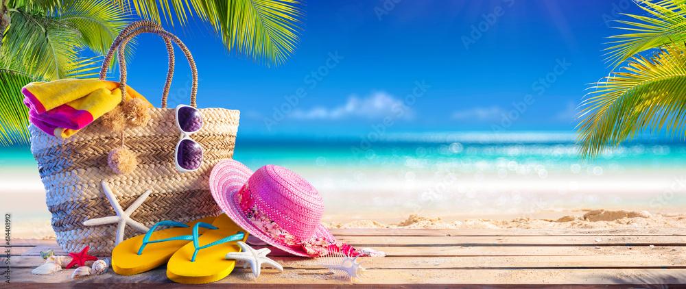 Summer Bag On Tropical Sand - Beach Vacation - Accessories Hat Towel And Flip Flops With Leaves Palm And Blue Sea